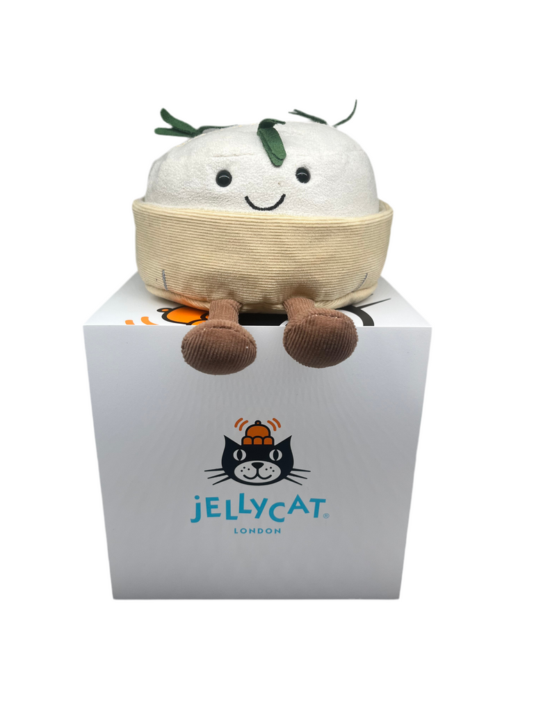 A white suedette Camembert with green rosemary stalks sat in a cream round tray with little brown corduroy legs