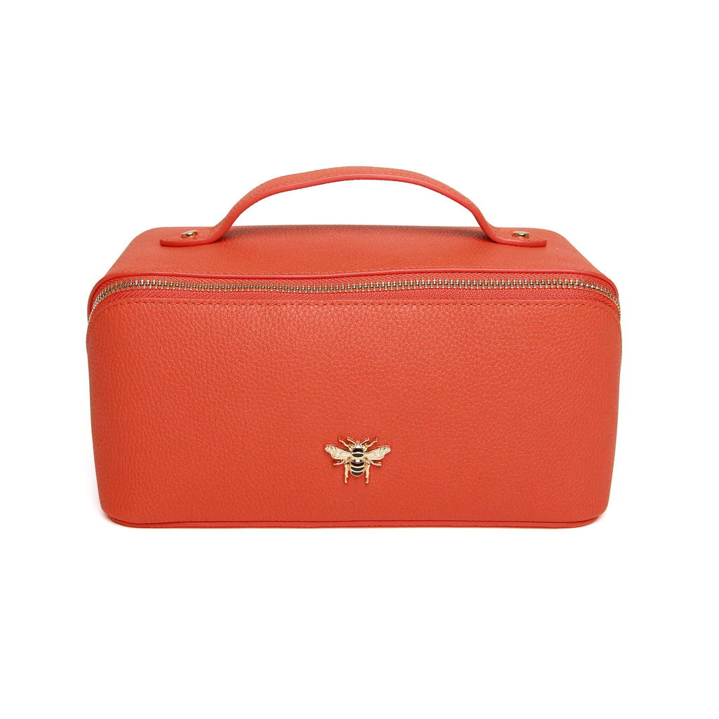orange leather makeup bag with gold trimmings, a handle, two compartments and gold bee on the front