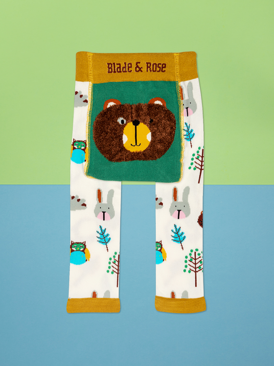 cream leggings covered with woodland creatures, bears, rabbits, owls  in blues , browns and greys with a mustard waistband and ankle trim with a furry bears face  on the bottom
