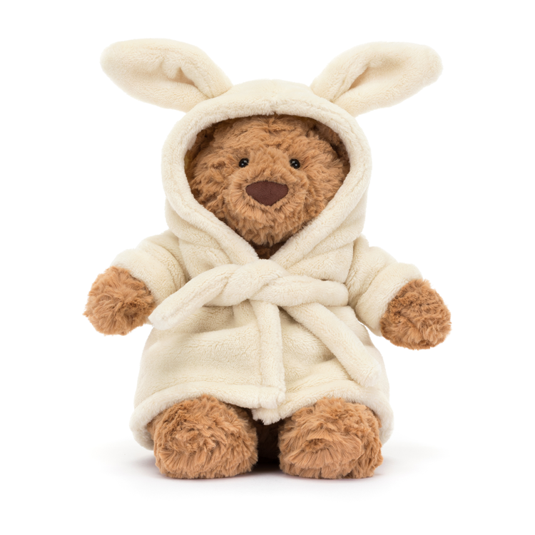 brown fluffy teddy bear with brown nose, black eyes and wearing a cream fleece bathrobe with bunny ears
