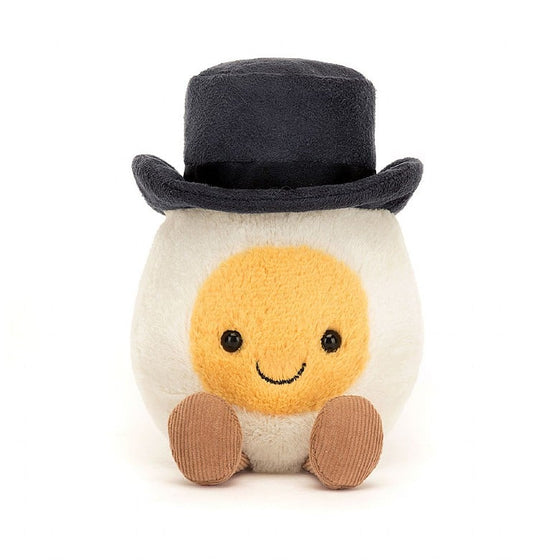 white boiled egg with a yellow smiley face, wearing a top hat and sat down with legs sticking out.