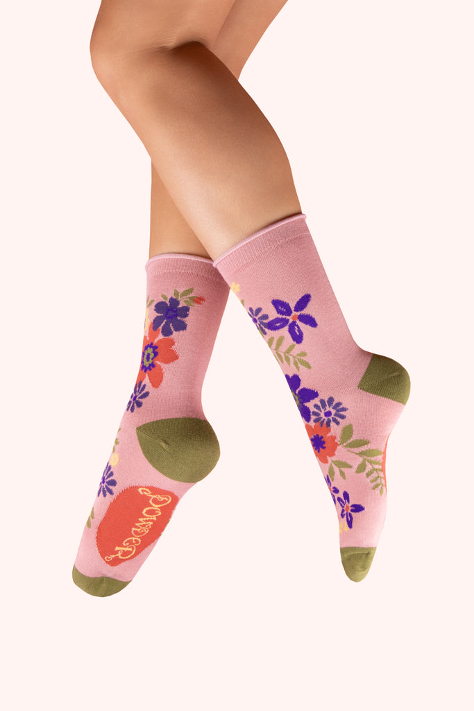Pink socks with floral designs and green toes and ankles.