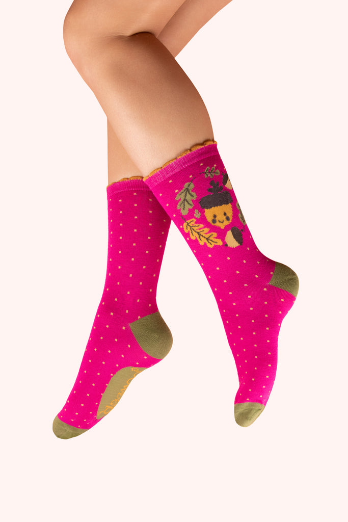 Pink socks with autumn-themed acorn design and green toes and ankles