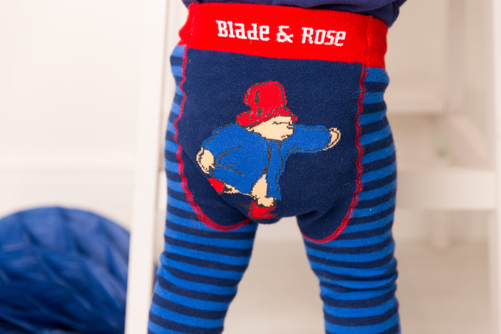 bright blue and navy blue leggings with a paddington bear on the bum wearing a red hat and wellington boots and a blue coat, red blade and rose waistband